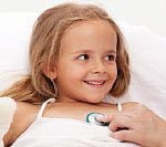 A little girl laying in bed with her arm around the head of another person.